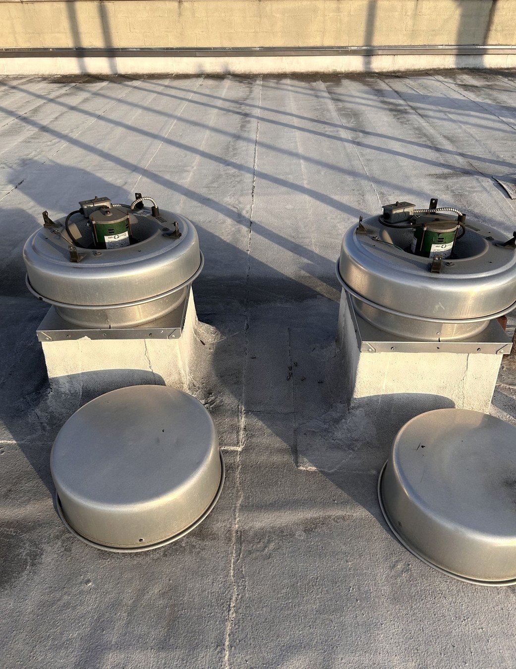 Two roof fans opened up during a maintenance visit